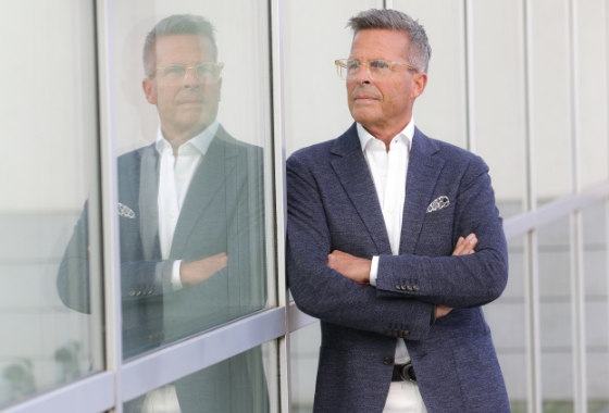 twin Werbeagentur | Business- und Imagefotografie | Geschäftsmann mit blauen modernen Anzug spiegelt sich in der Fensterfassade